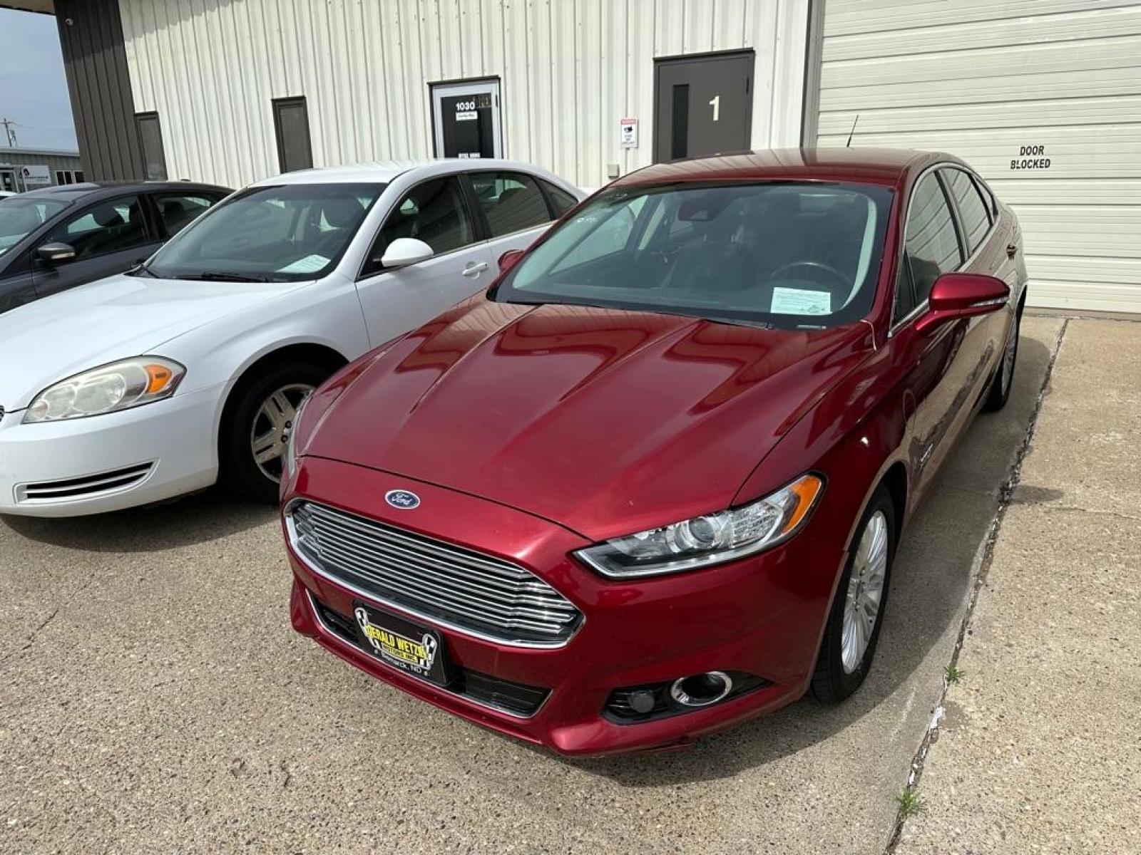 2013 RED FORD FUSION TITANIUM PHEV (3FA6P0SU7DR) with an 2.0L engine, Continuously Variable transmission, located at 1030 S. 22nd St., Bismarck, ND, 58504, (701) 258-0022, 46.793560, -100.758118 - This Hybrid vehicle combines electric and gasoline propulsion to provide break through performance and improve efficiency. While operating in Hybrid mode it is estimated at 42MPG combined. - Photo #4